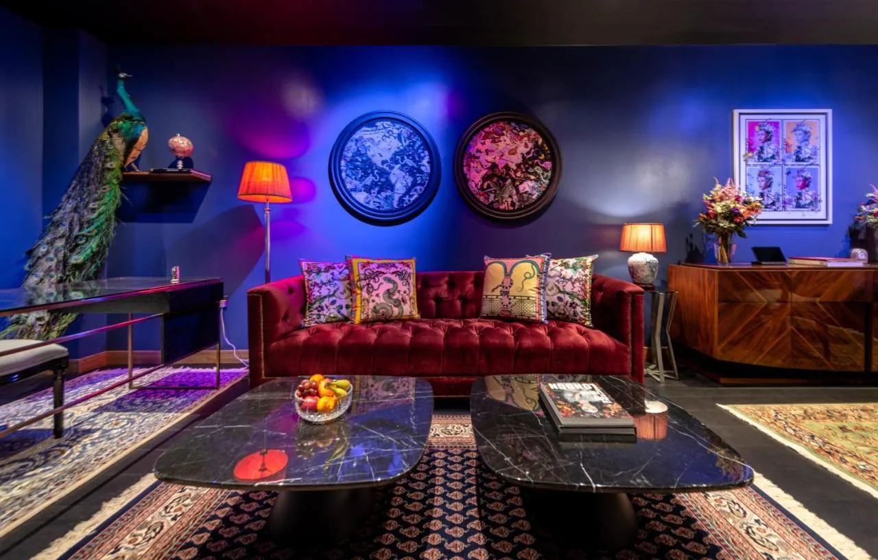 Living room with red couch and blue wall inside Hux Hotel, Kensington