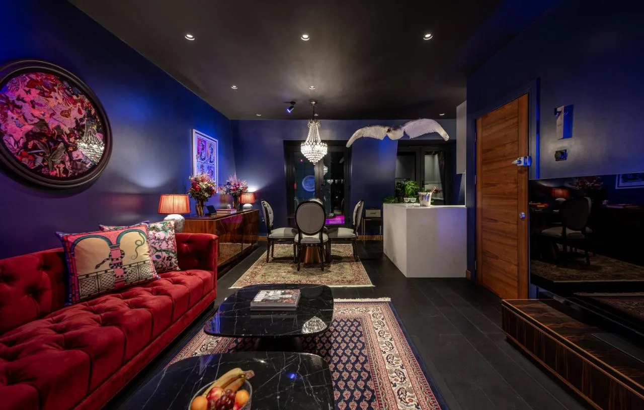 Living room with red couch and table at Hux Hotel, Kensington apartment