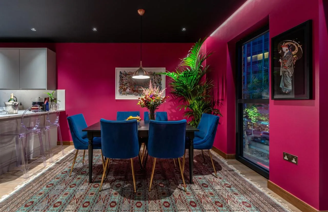 Dining room with pink walls and blue chairs at Hux Hotel, Kensington