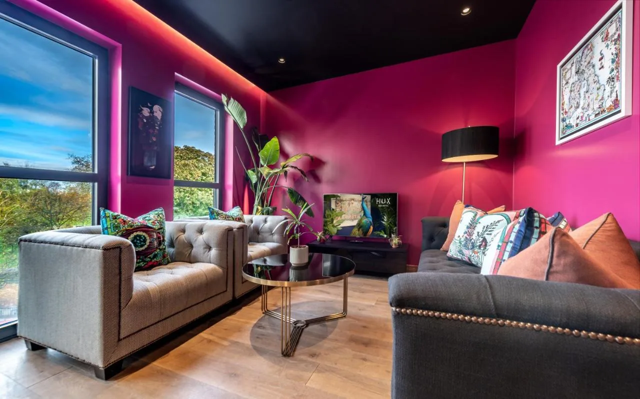 Sitting room with two couches and pink walls at Hux Hotel, Kensington